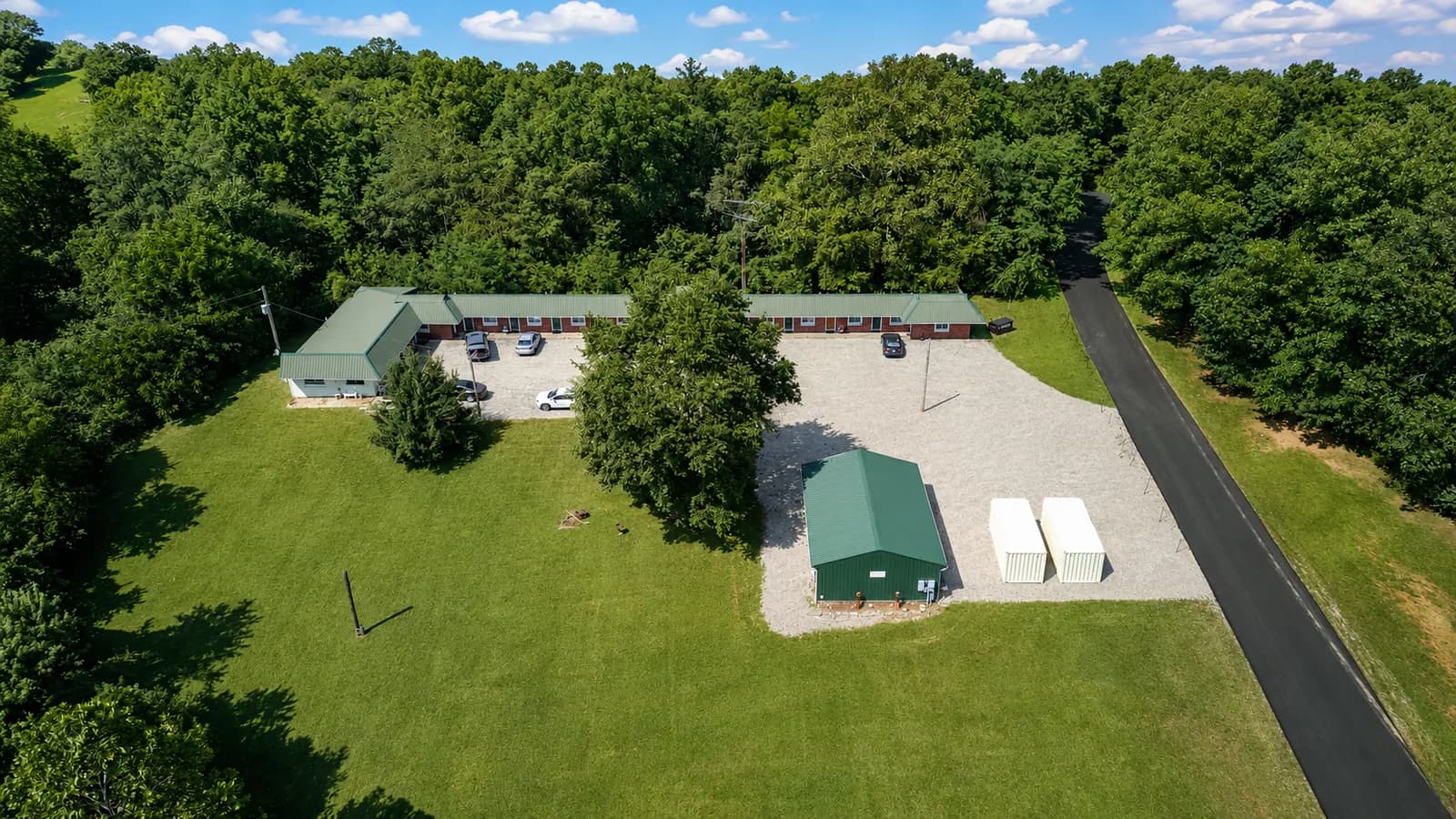 Aerial view of the motel grounds surrounded by lawn and mature trees