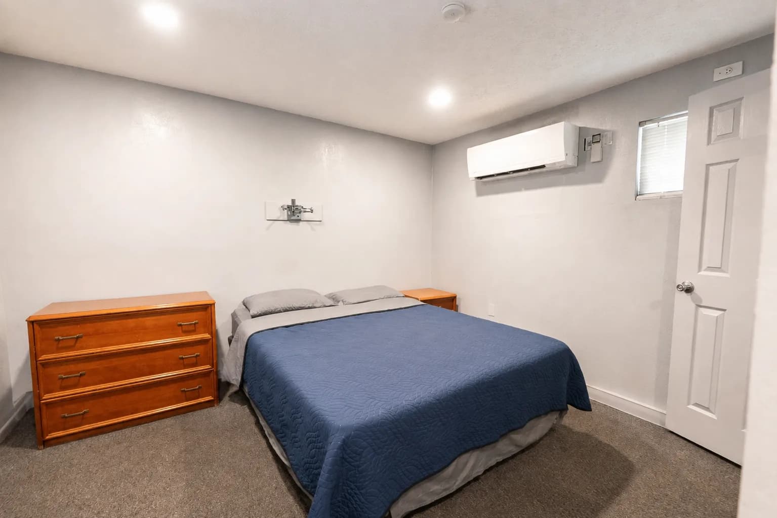 Bright guest room with a queen bed and a wooden dresser