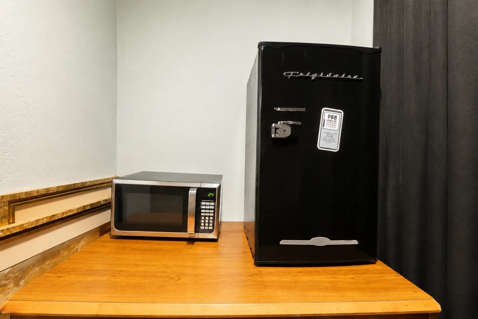 In-room mini fridge and microwave on a wooden counter