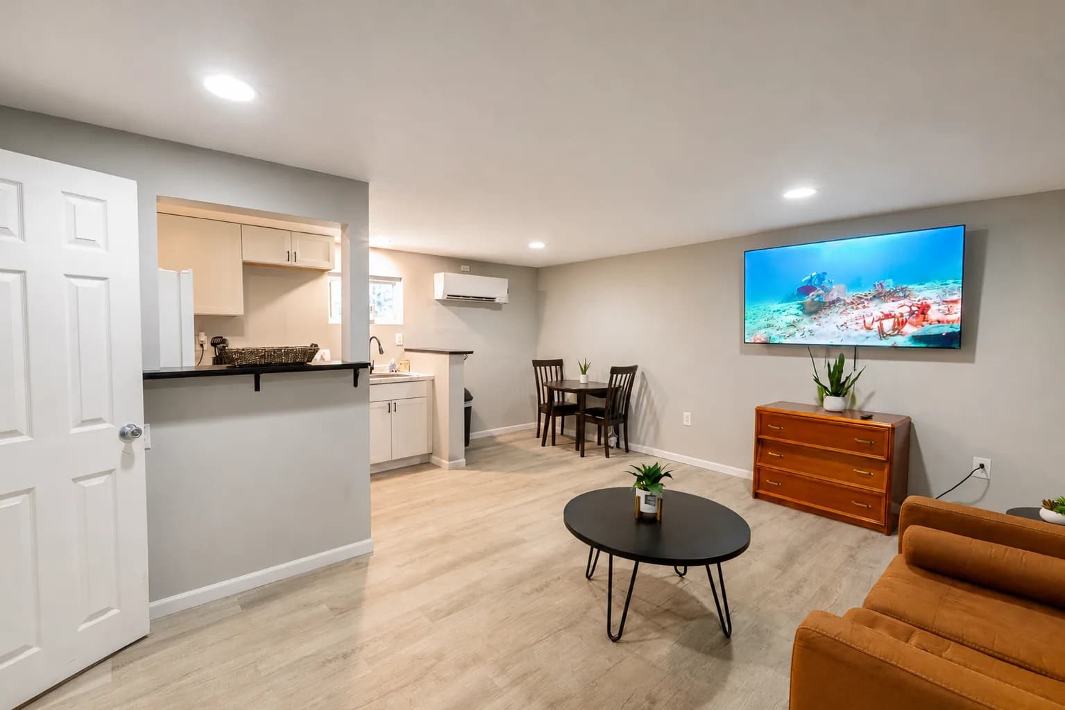 Open-plan suite with a living area, breakfast bar, kitchen, and dining table